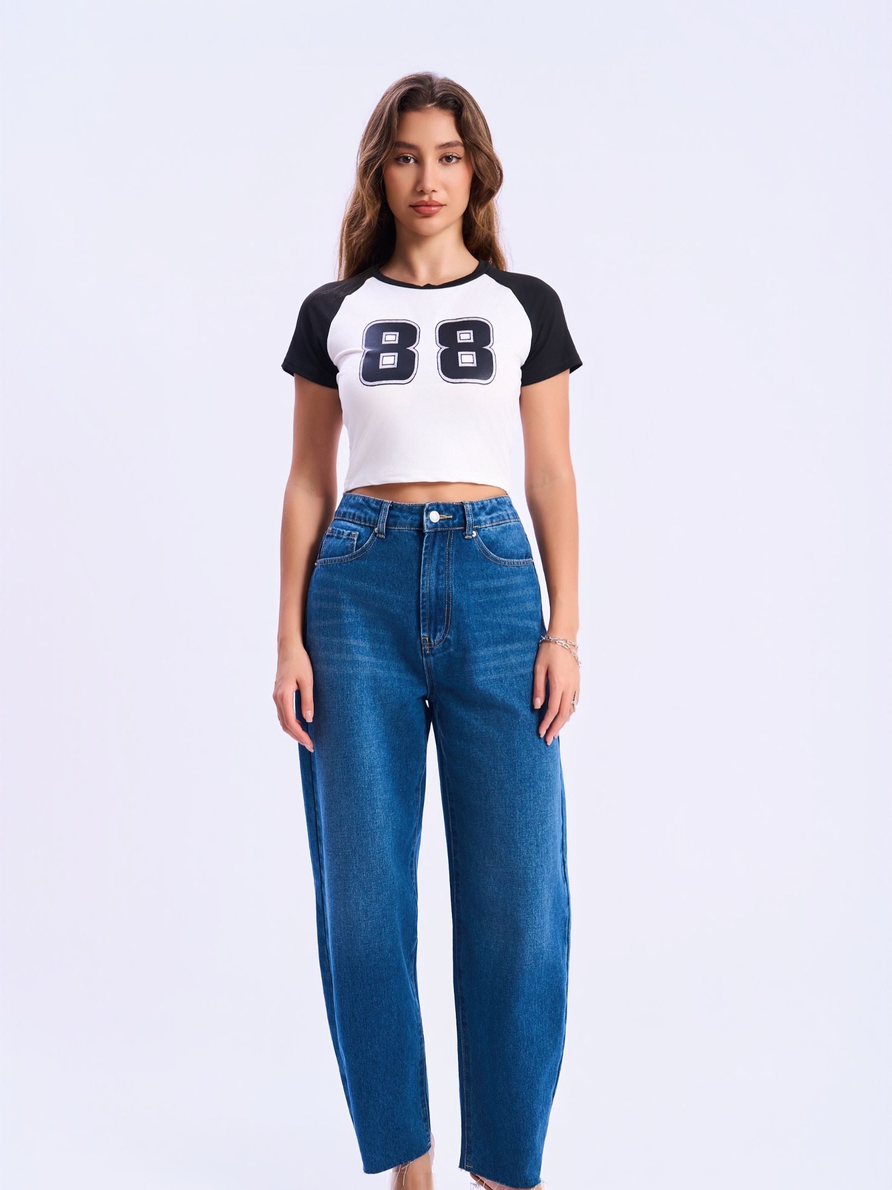 Woman wearing a white and black shirt and blue jeans on a white background